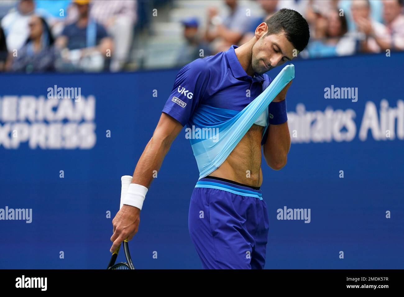 Novak Djokovic, of Serbia, wipes sweat from his face between