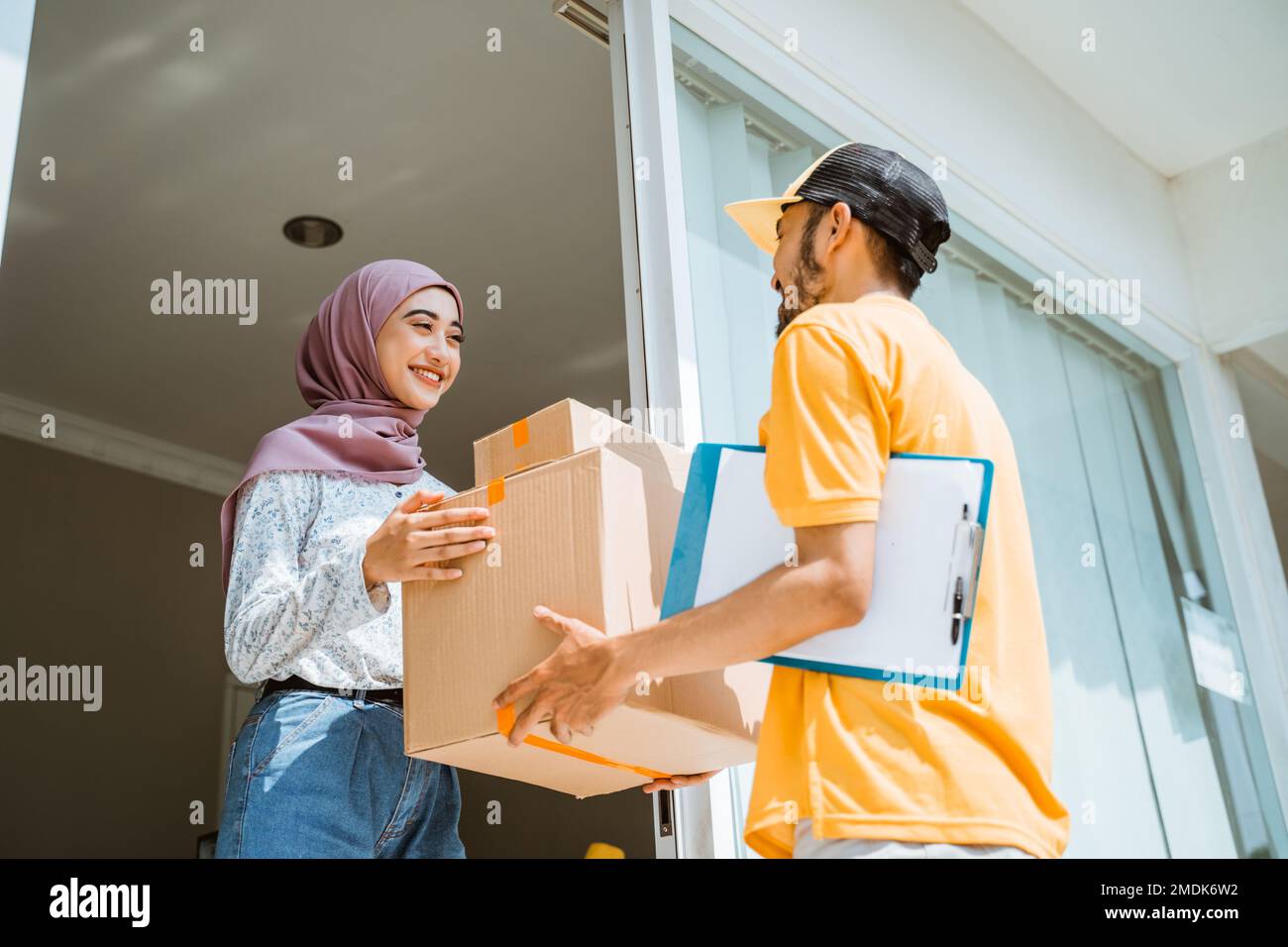 delivery man in yellow uniform delivering package boxes to customers ...