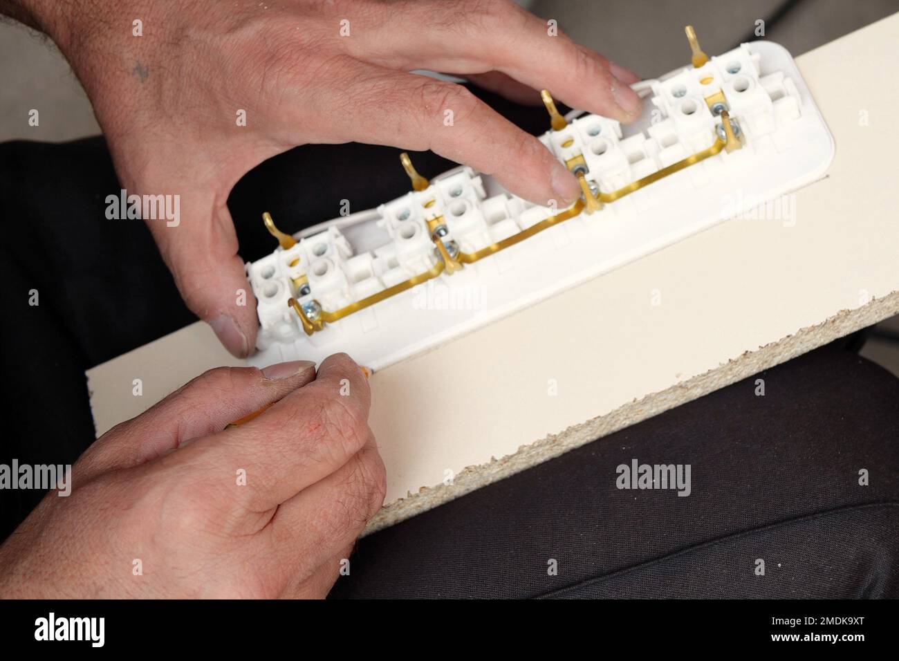 man making an extension cord socket outdoor Stock Photo Alamy
