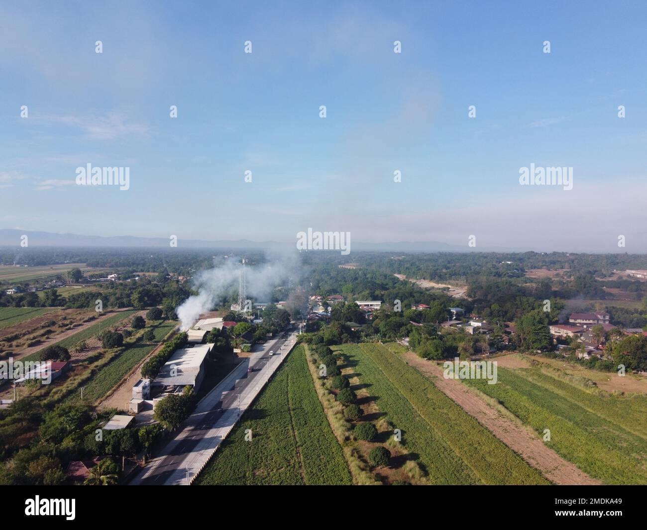 Drone image capture over a smoking field and farm landscape Stock Photo