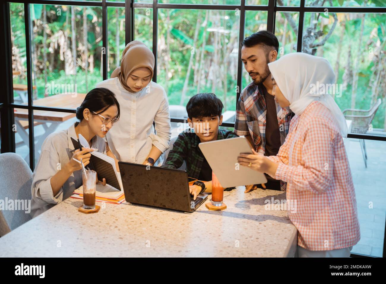 group of asian students using a tablet and a laptop Stock Photo - Alamy