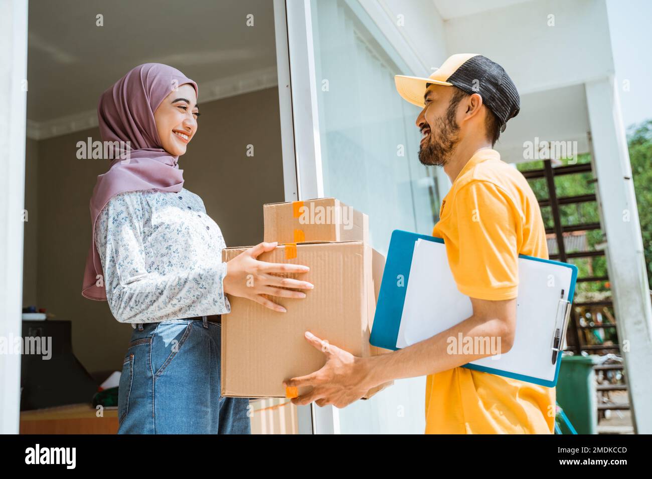 girl in veil is happy when the delivery man delivers Stock Photo - Alamy