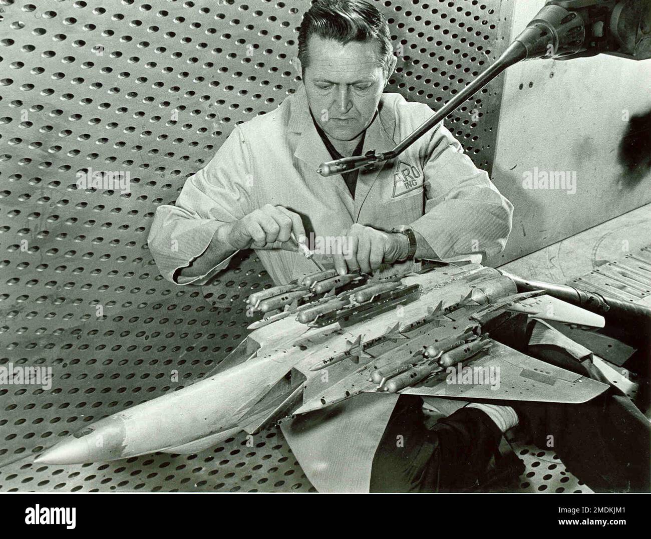 Test facility craftsman B.R. Robison prepares a scale model of the F15