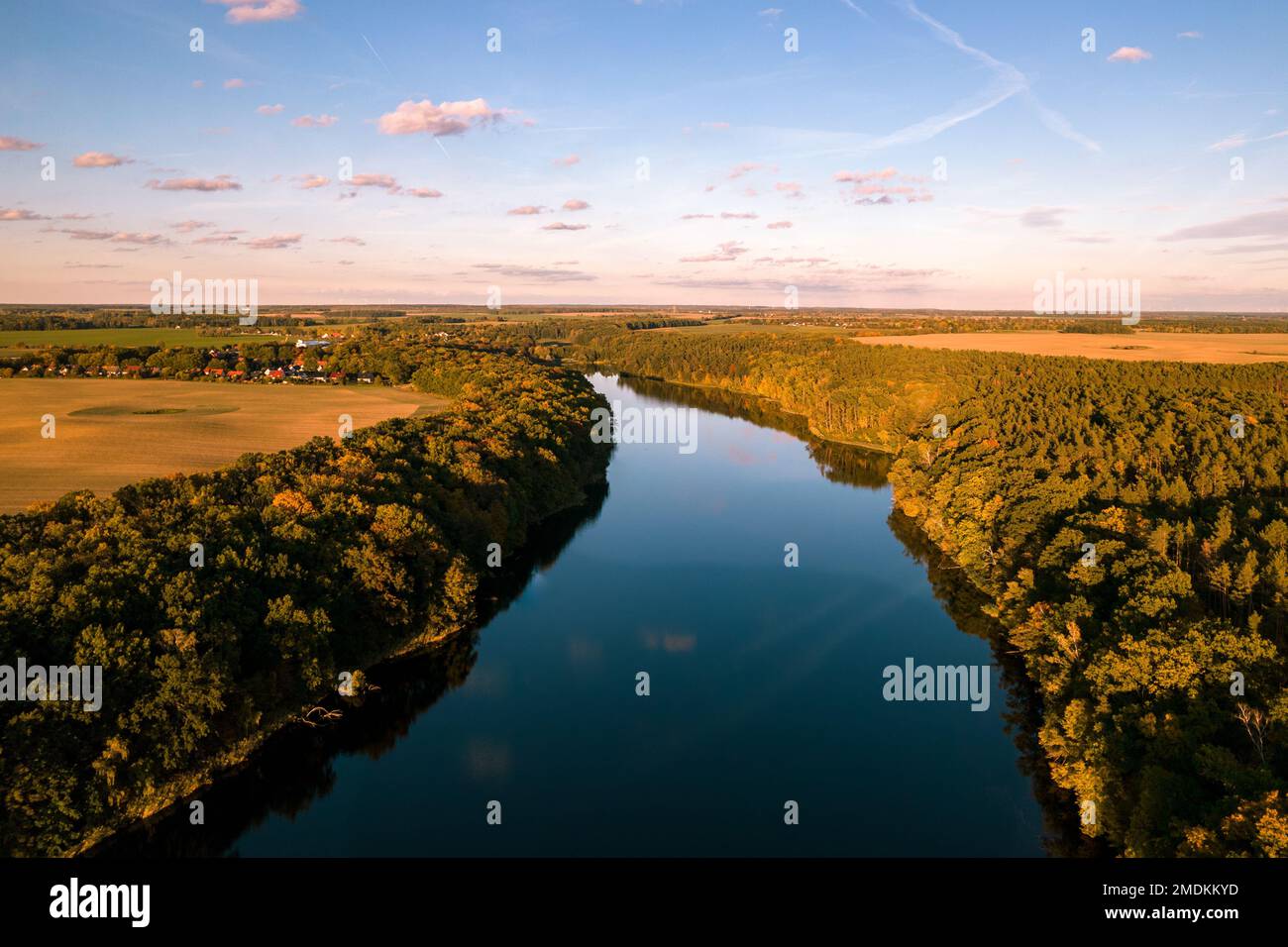 An aerial view of a river surrounded by green landscape under a cloudy ...