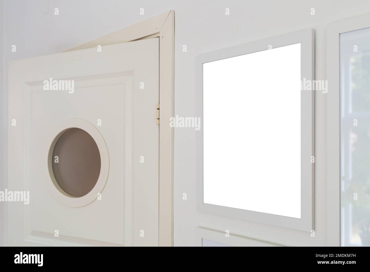 White wooden picture frame with mockup space for photography hanging on living room wall, selective focus Stock Photo