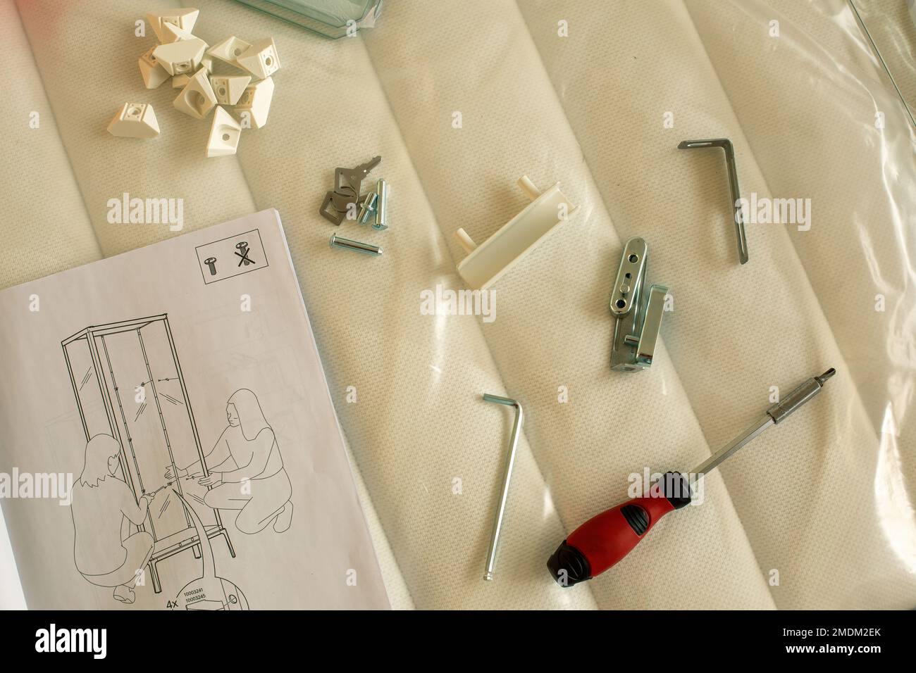 Parts and tools for self assembly furniture lying on mattress Stock
