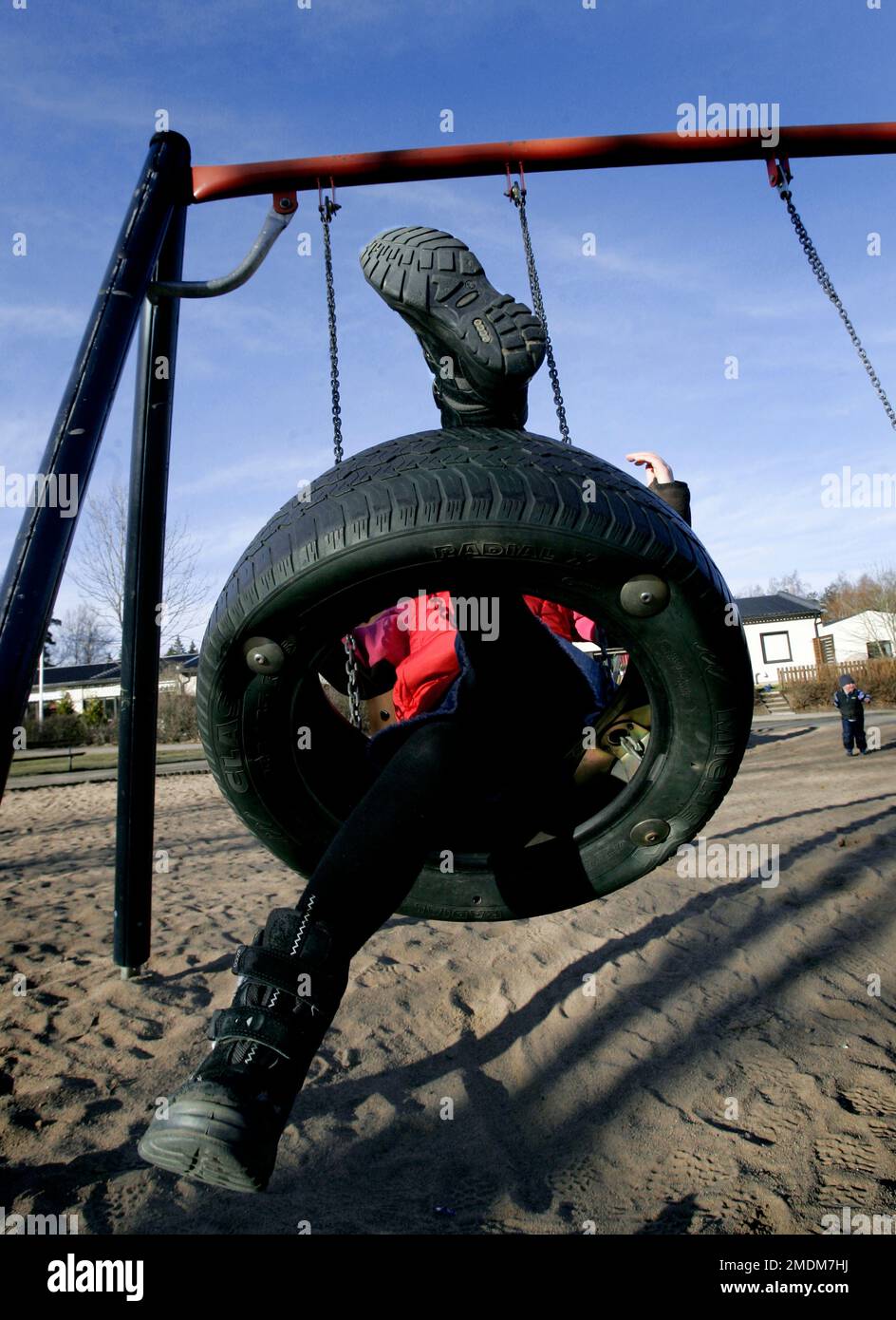 A playground for children, children in a swing in a residential area. Stock Photo