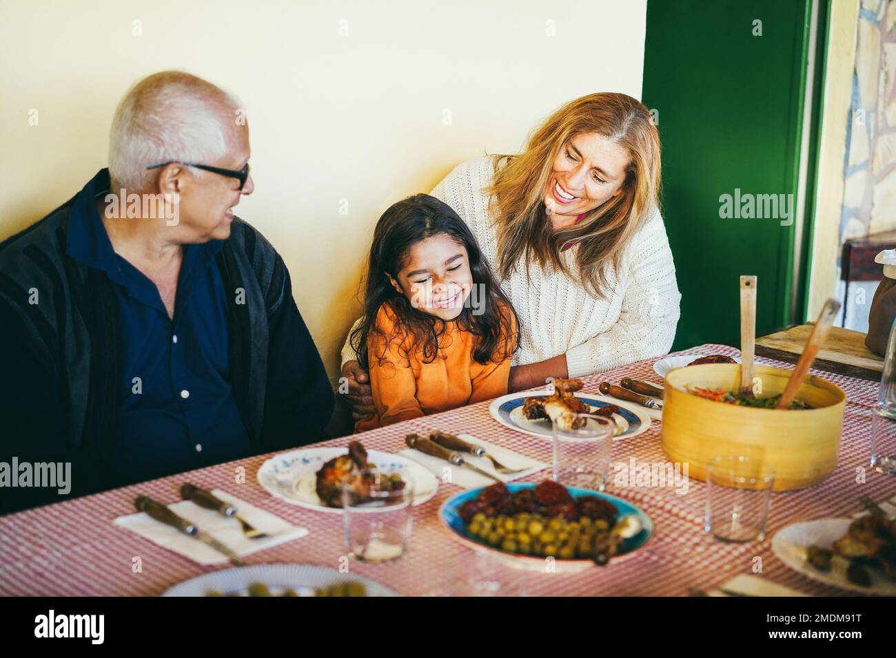 Happy grandparents eating with grand-daughter at home patio - Soft focus on grandmother face Stock Photo