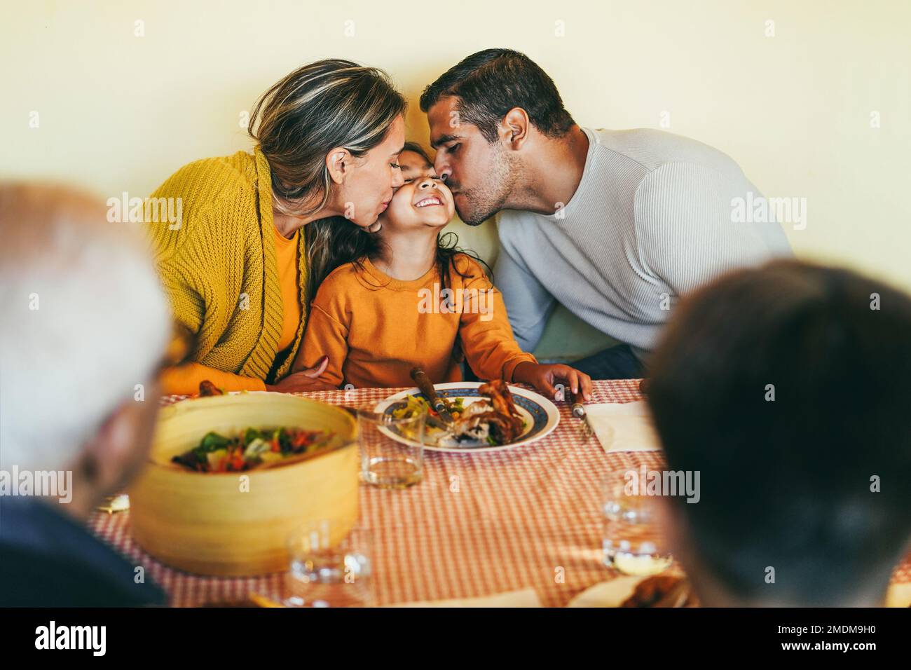 Latin parents having fun with children during home dinner - Focus on mother face Stock Photo