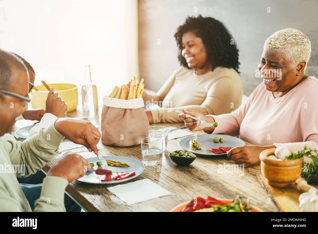 Happy african family eating lunch together at home - Focus on mother face Stock Photo