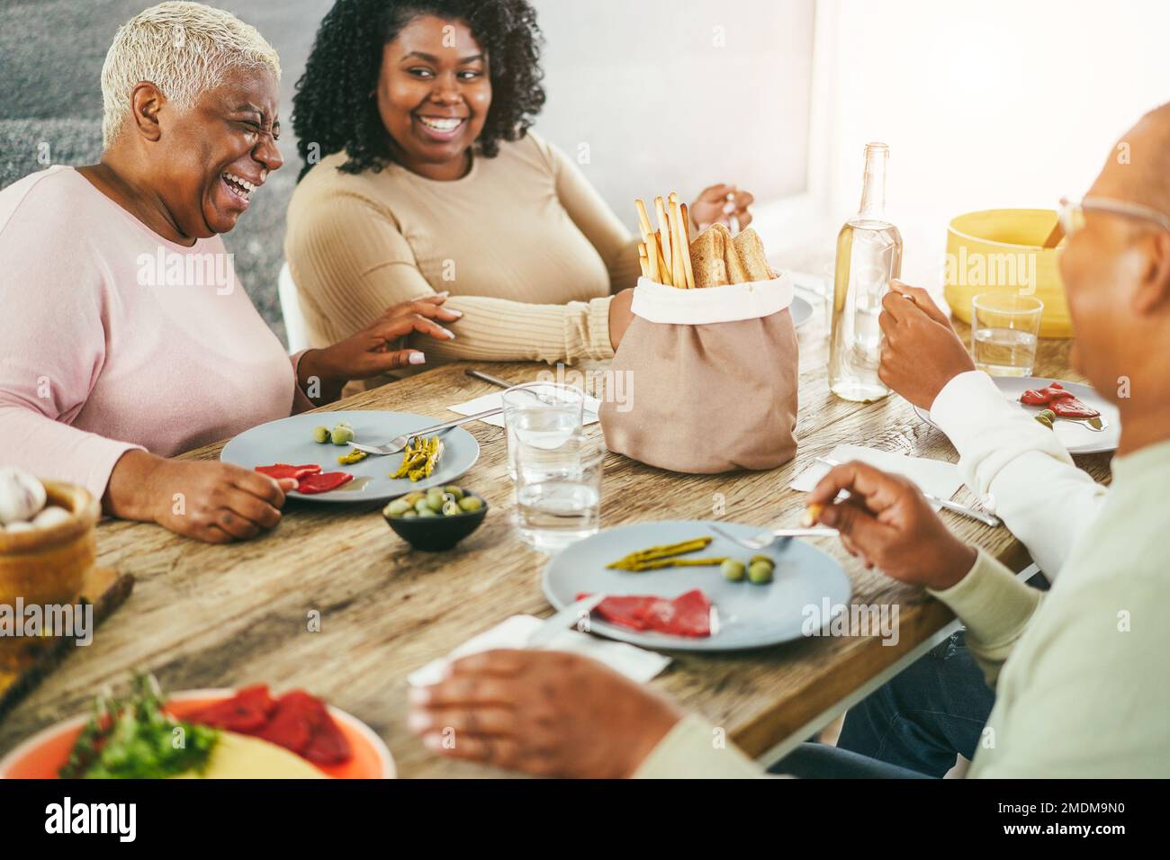Happy african family eating lunch together at home - Focus on mother face Stock Photo