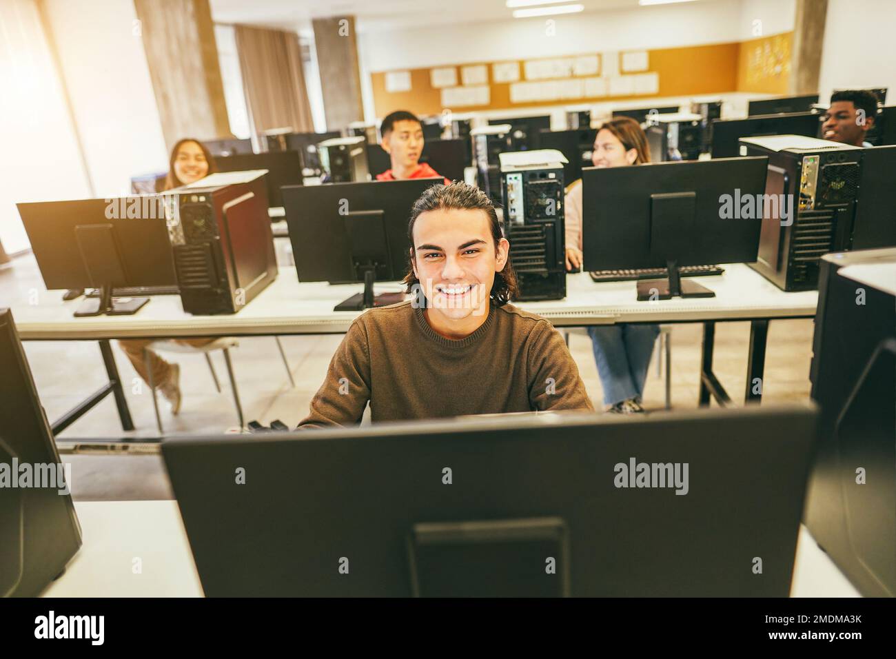 Young students using computers inside technology class at school room ...