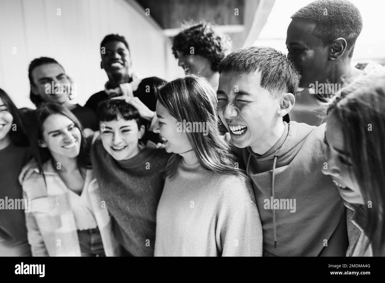 Young group of friends having fun outdoor - Focus on asian guy face - Black and white editing Stock Photo