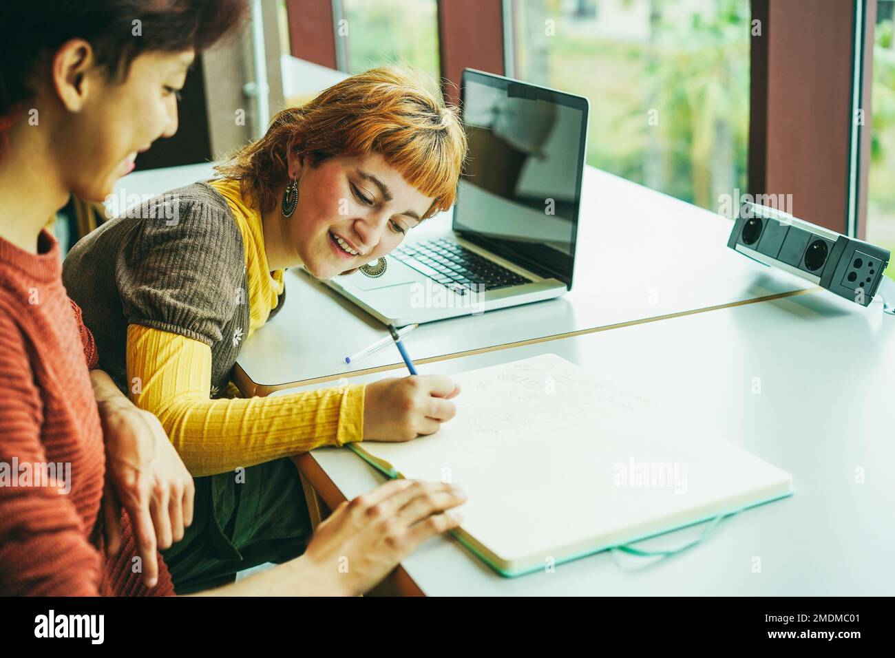 Young multiracial students studying inside university library - Focus on girl face Stock Photo