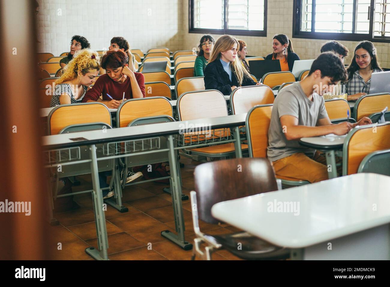 Young multiethnic students working together inside classroom at school university - Focus on blond girl face Stock Photo