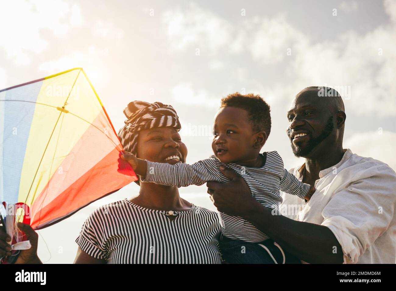 African family having fun with kite on the beach - Focus on father face Stock Photo