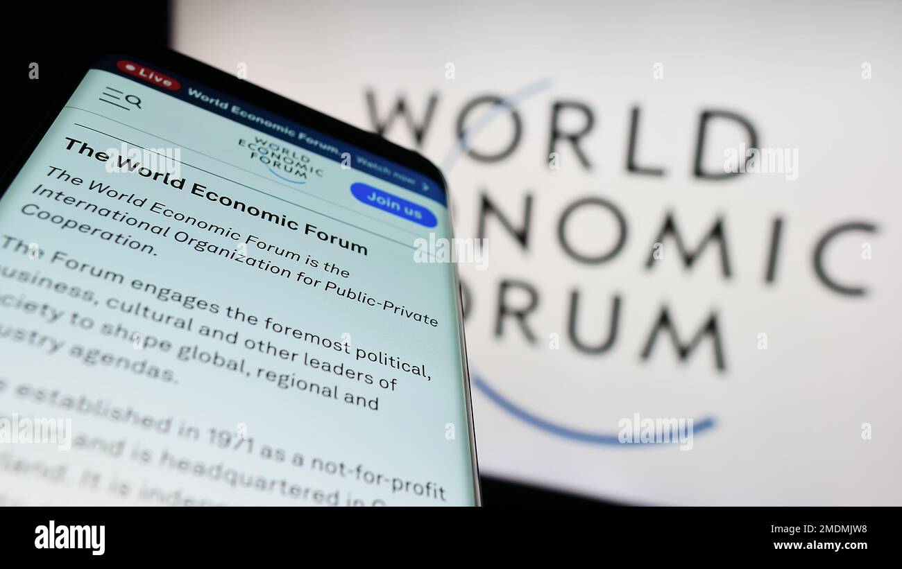 Mobile phone with website of organisation World Economic Forum (WEF) on screen in front of logo. Focus on top-left of phone display. Stock Photo