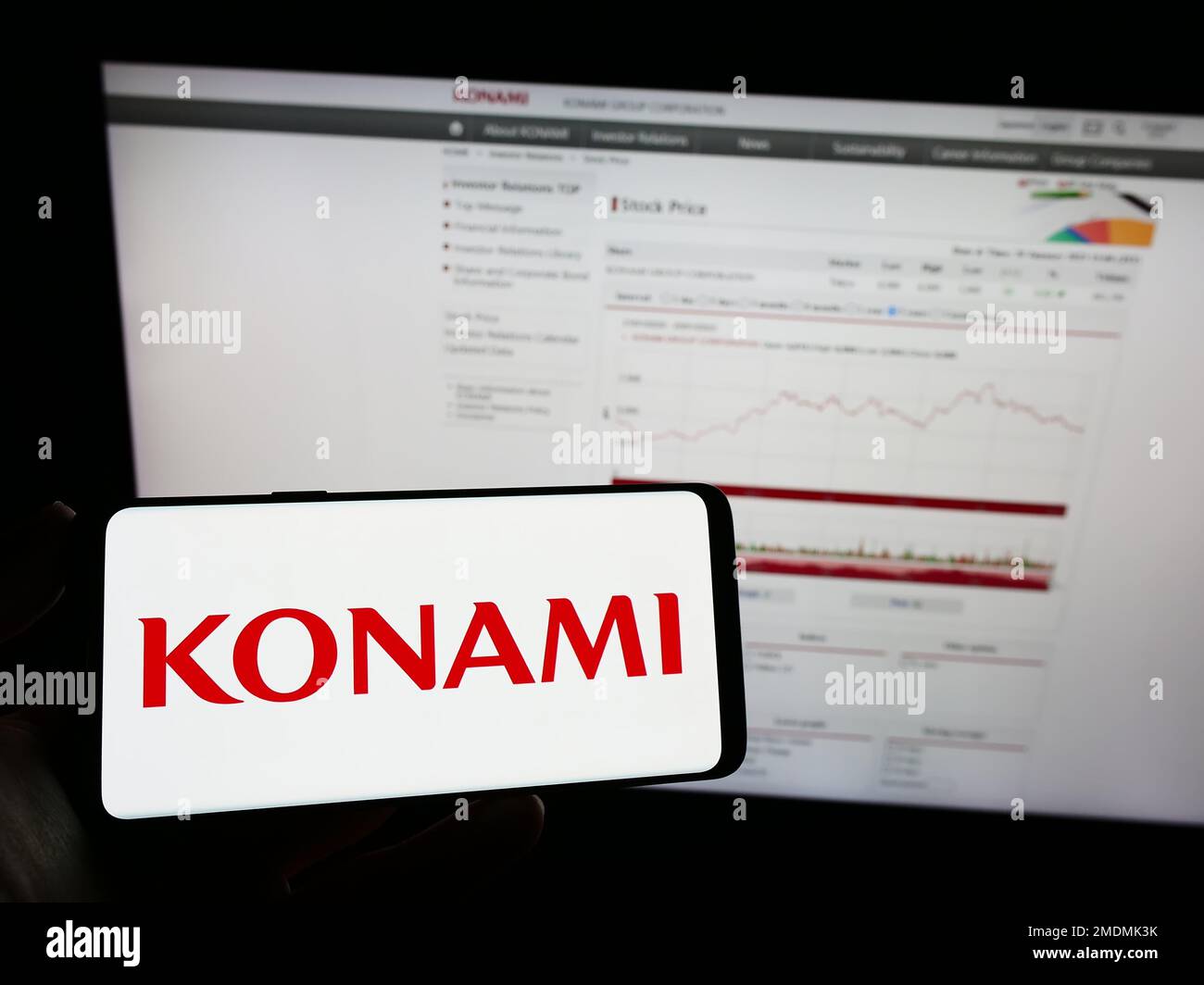 Person Holding Mobile Phone With Logo Of Japanese Company Konami Group