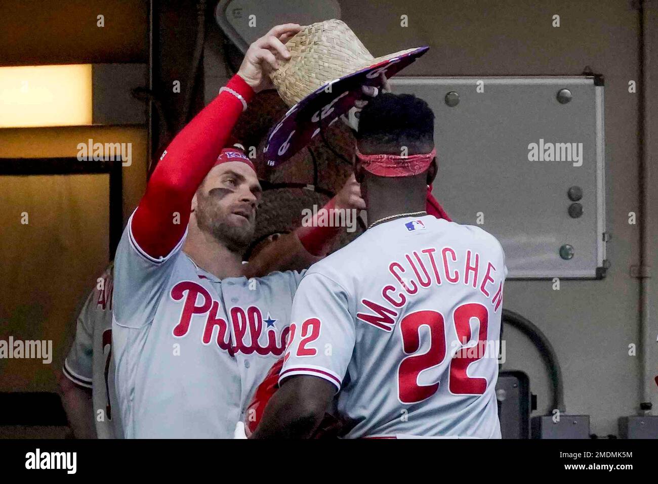Philadelphia Phillies' Bryce Harper gives Andrew McCutchen a hat after a  home run during the eighth inning of a baseball game against the Milwaukee  Brewers Monday, Sept. 6, 2021, in Milwaukee. (AP