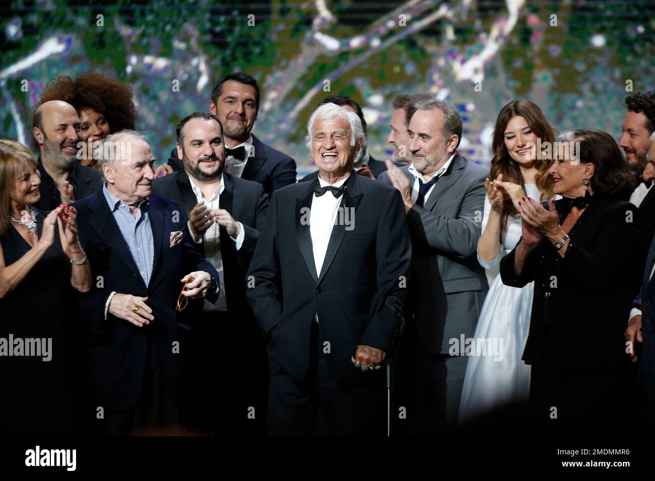 FILE - In this Feb. 24, 2017 file photo, French actor Jean-Paul Belmondo,  center, is congratulated by actors on stage during the ceremony of the 42nd  Cesar Film Awards, at the Salle