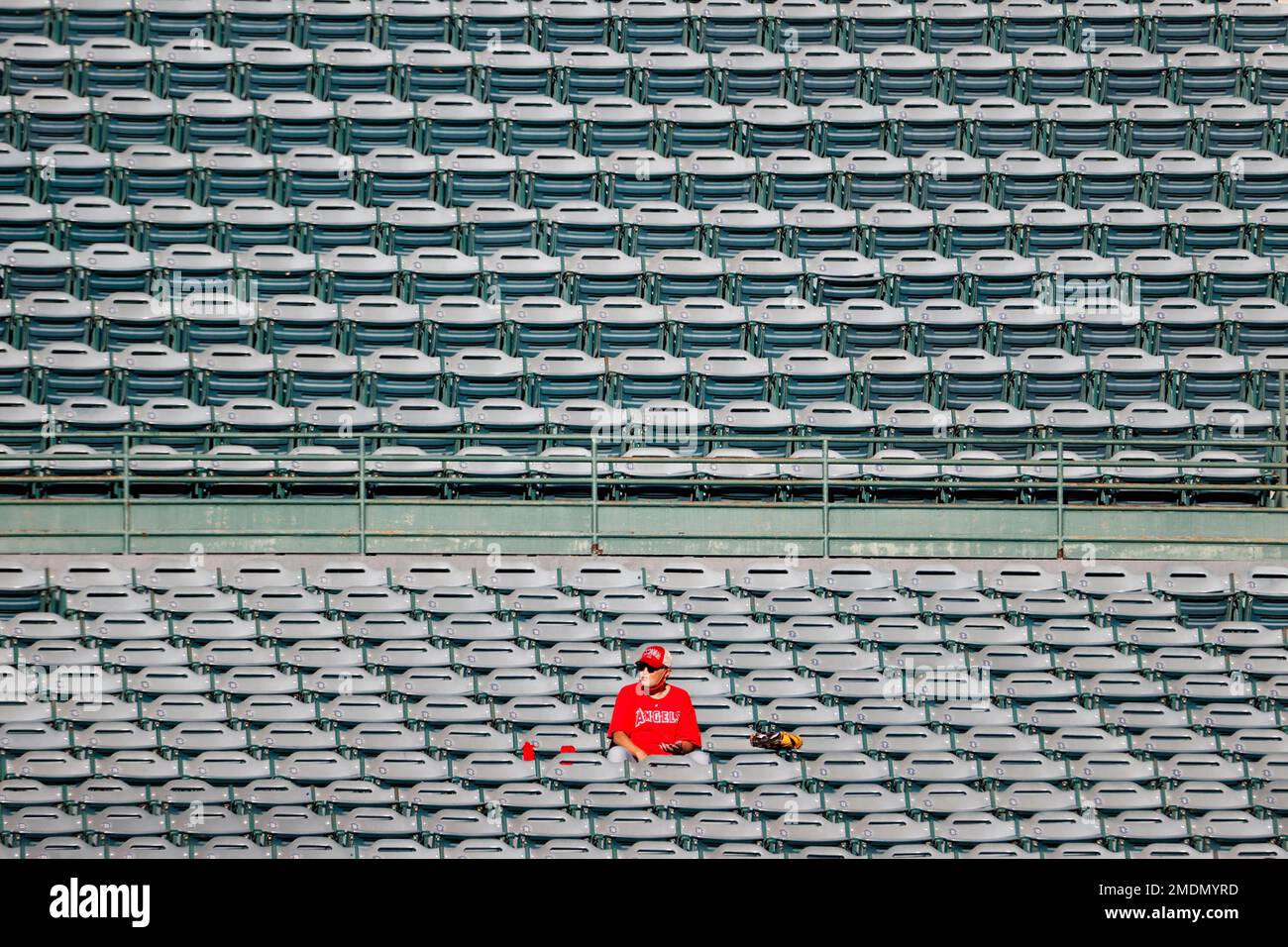 Texas Rangers Stand A baseball fan sits alone in a stand prior to a baseball game between ...