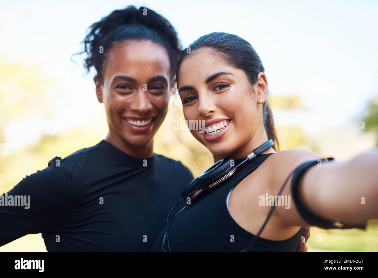 But first, lets take a selfie. Cropped portrait of two attractive young women posing for a selfie after their run together in the park. Stock Photo