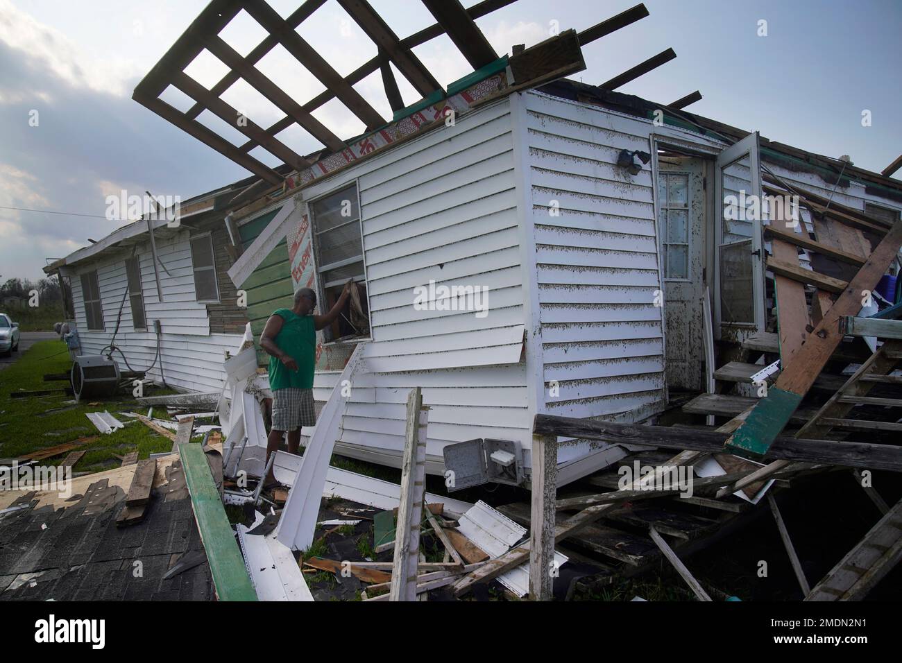 Randy Manuel looks in the window of his and his mother's hurricane