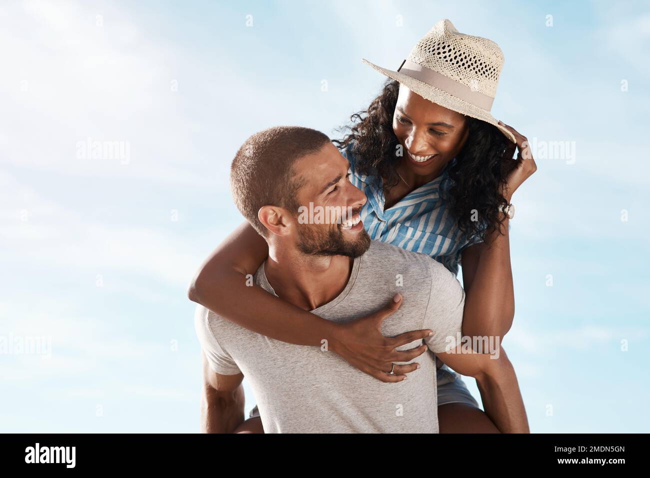 Our love is something special. a young man piggybacking his girlfriend at the beach. Stock Photo