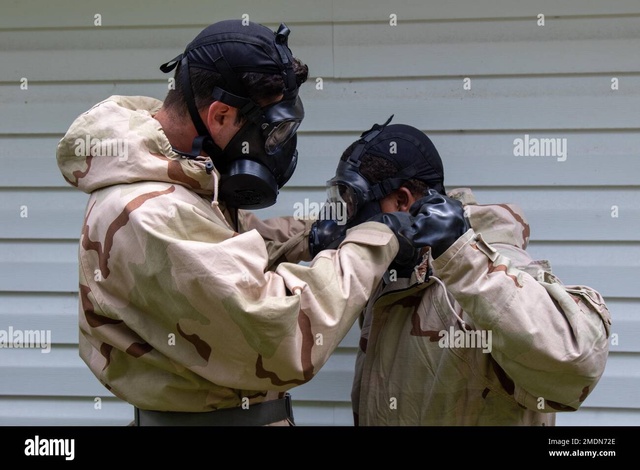 Soldiers from 4th Battalion, 3rd Aviation Regiment, 3rd Combat Aviation Brigade, 3rd Infantry Division assist each other with fitting their M50 Protective Mask at Fort Stewart, Georgia, July 26, 2022. Chemical, Biological, Radiological and Nuclear training is required every year and reinforces proper procedures during a CBRN event. Stock Photo