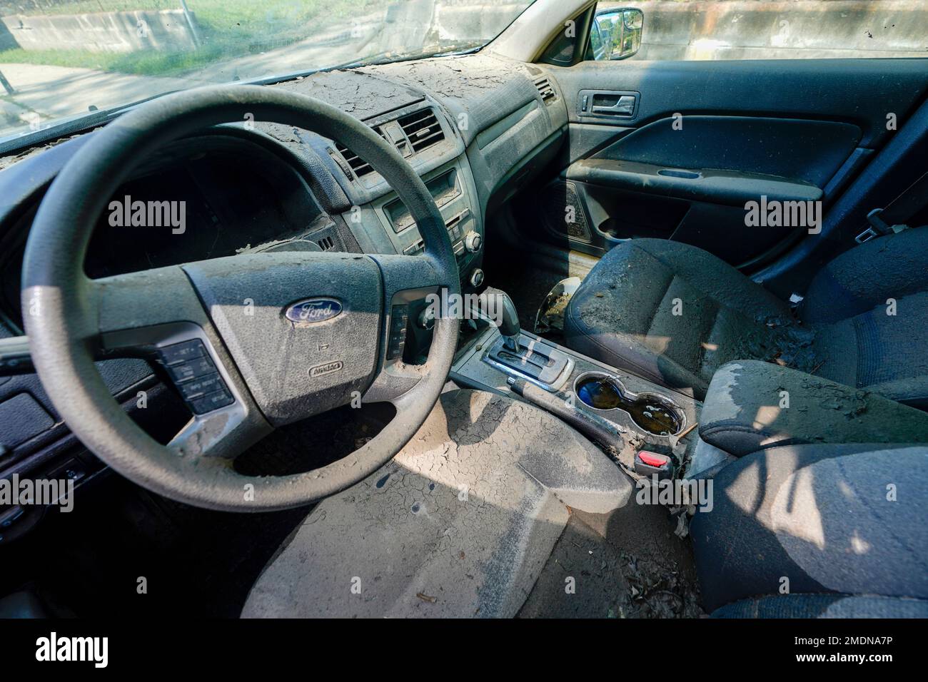 The interior of a car damaged by the flood is seen covered in mud