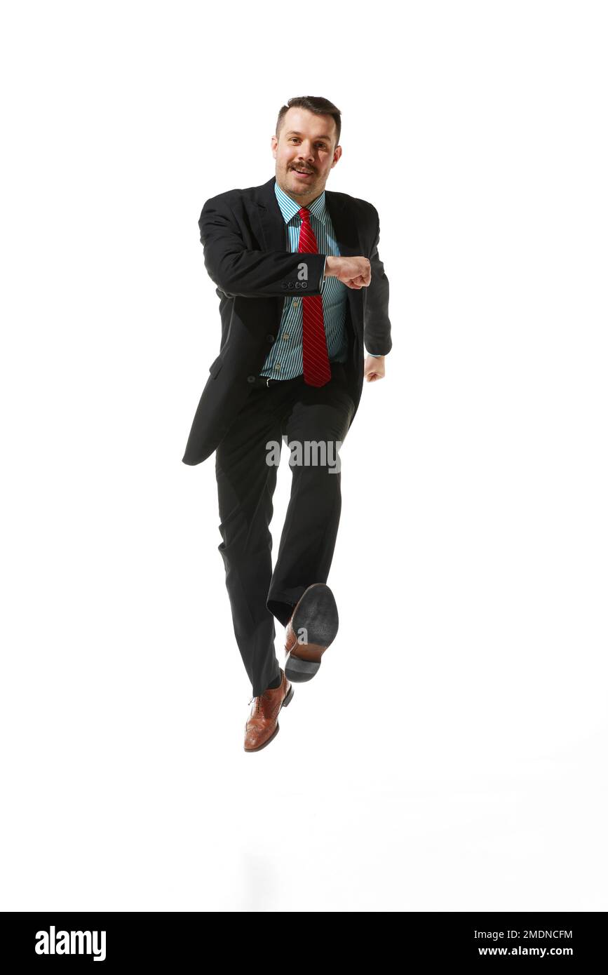 Front view. Businessman in a suit with positive mood walking to work over white studio