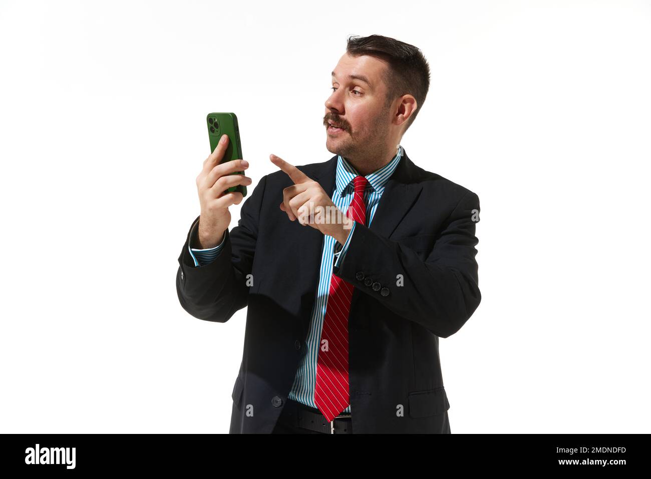 Businessman in a suit looking on phone over white studio background. Online work, communication. Concept of business, career, innovations, ad Stock Photo