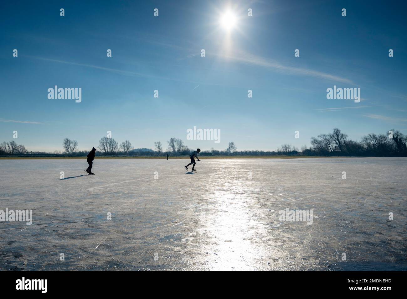Bluntisham, Cambridgeshire, UK. 23rd Jan, 2023. People enjoy the cold snap with some fen skating in sunshine as the cold winter weather continues. Ice skating in the fens is a popular pastime as the shallow flooded flat fields can freeze to allow safe skating. This is the first winter for about 10 years when sharp overnight frosts have lasted long enough to allow the water to freeze. Credit: Julian Eales/Alamy Live News Stock Photo