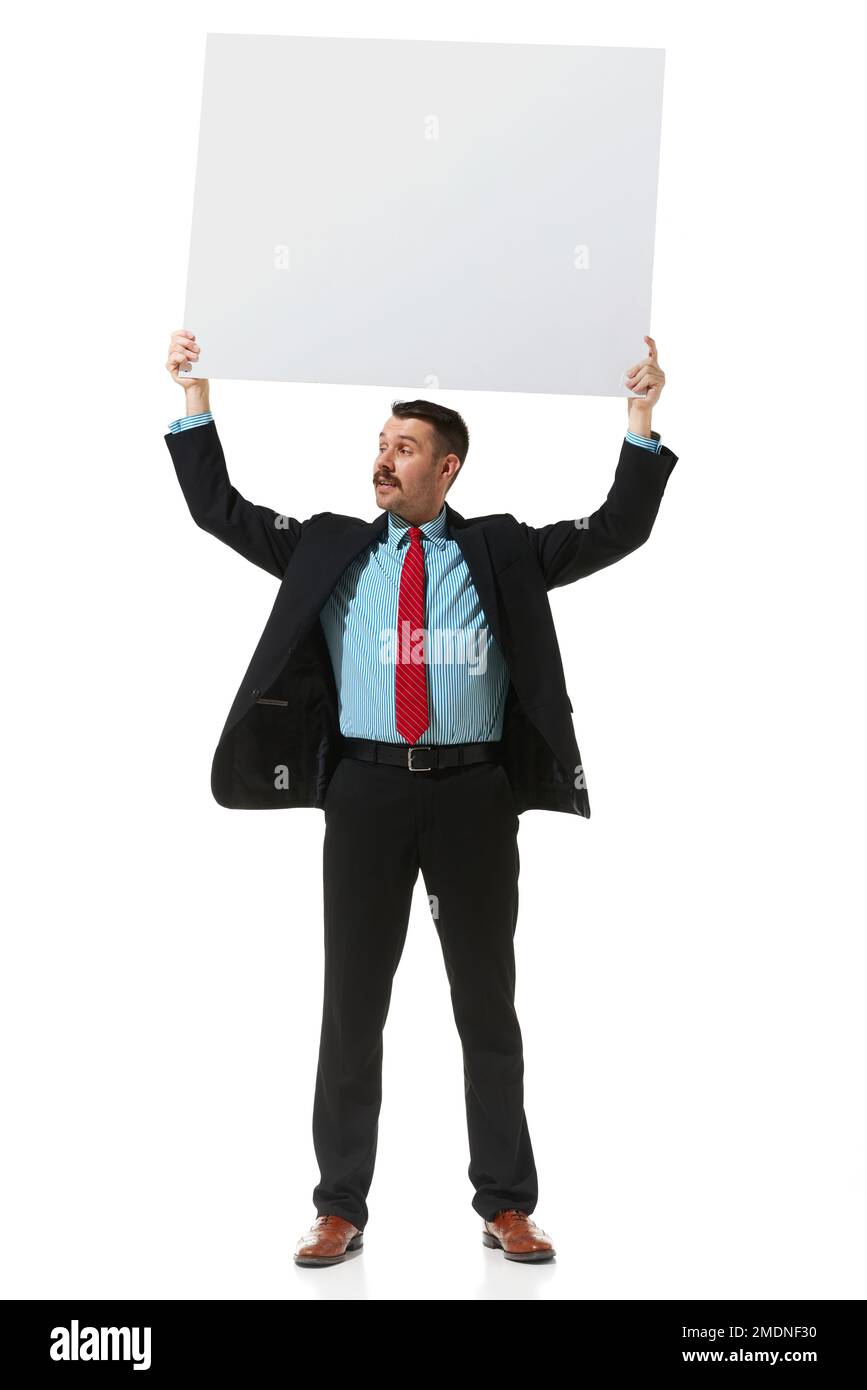 Businessman in a suit holding big empty paper for text over white studio background. Vacancy. Concept of business, career, innovations, ad Stock Photo