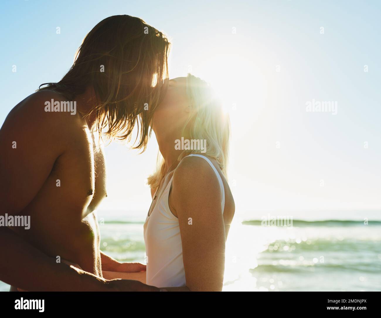 Theyve never felt closer. an affectionate young couple kissing each other at the beach. Stock Photo