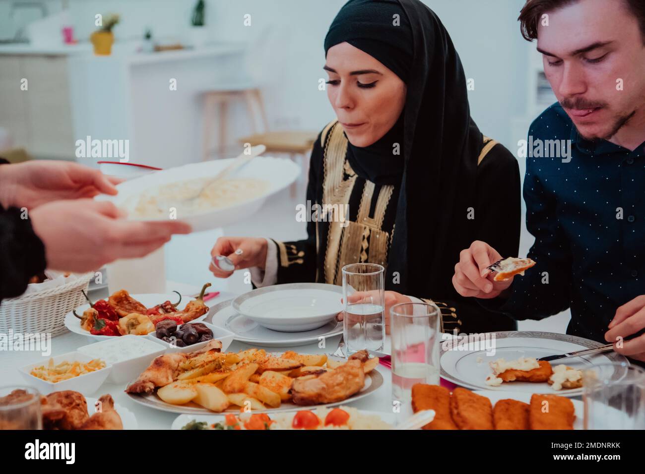 Muslim family having Iftar dinner drinking water to break feast. Eating