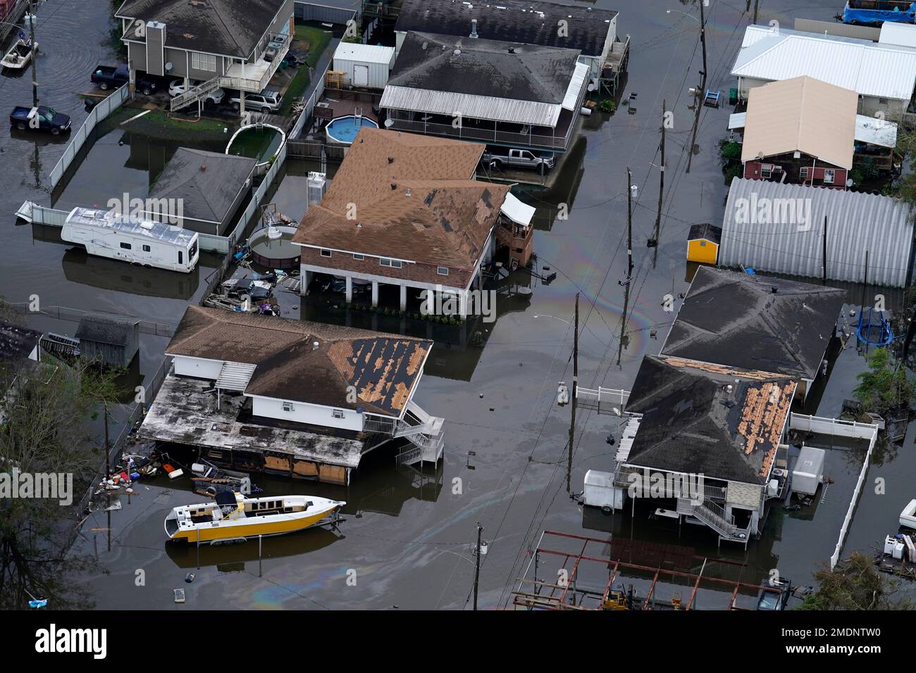 An oil slick drifts between damaged homes in the aftermath of Hurricane