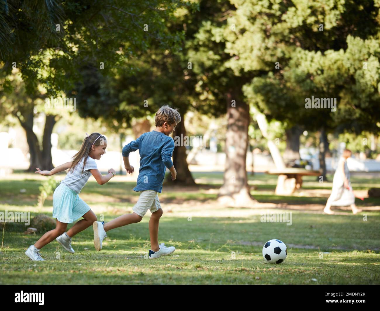 Whos going to be the next football star. an adorable little boy and girl playing soccer in the park. Stock Photo