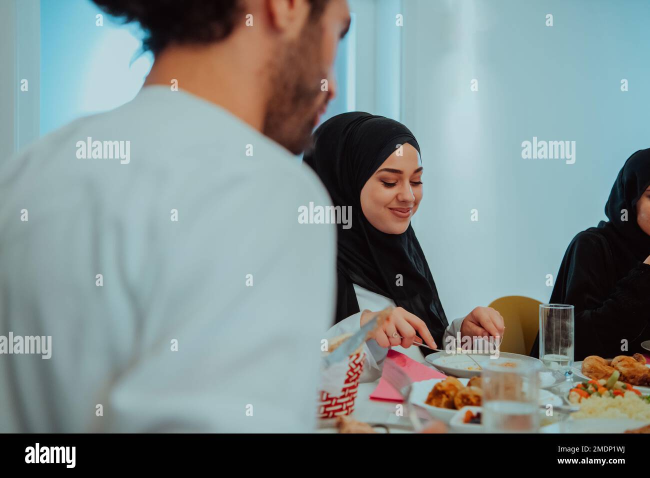 Muslim family having Iftar dinner drinking water to break feast. Eating