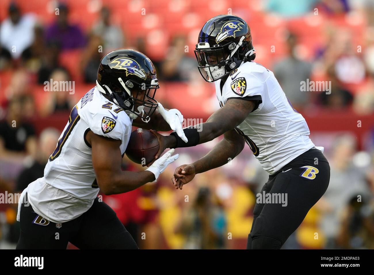 Baltimore Ravens quarterback Lamar Jackson (8) hands off to running