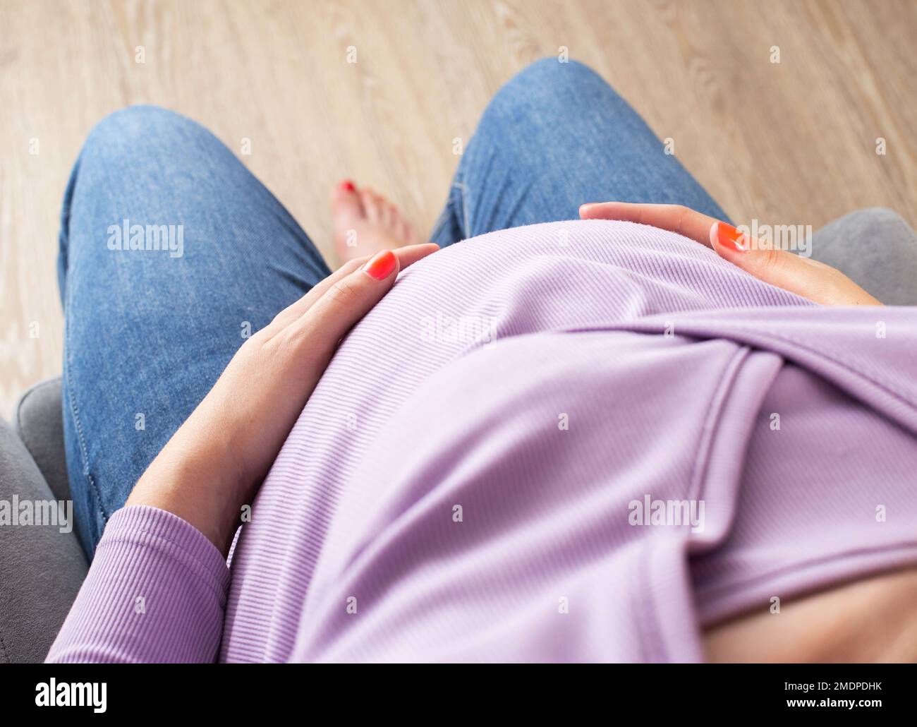 Sad pregnant woman sitting chair hi-res stock photography and