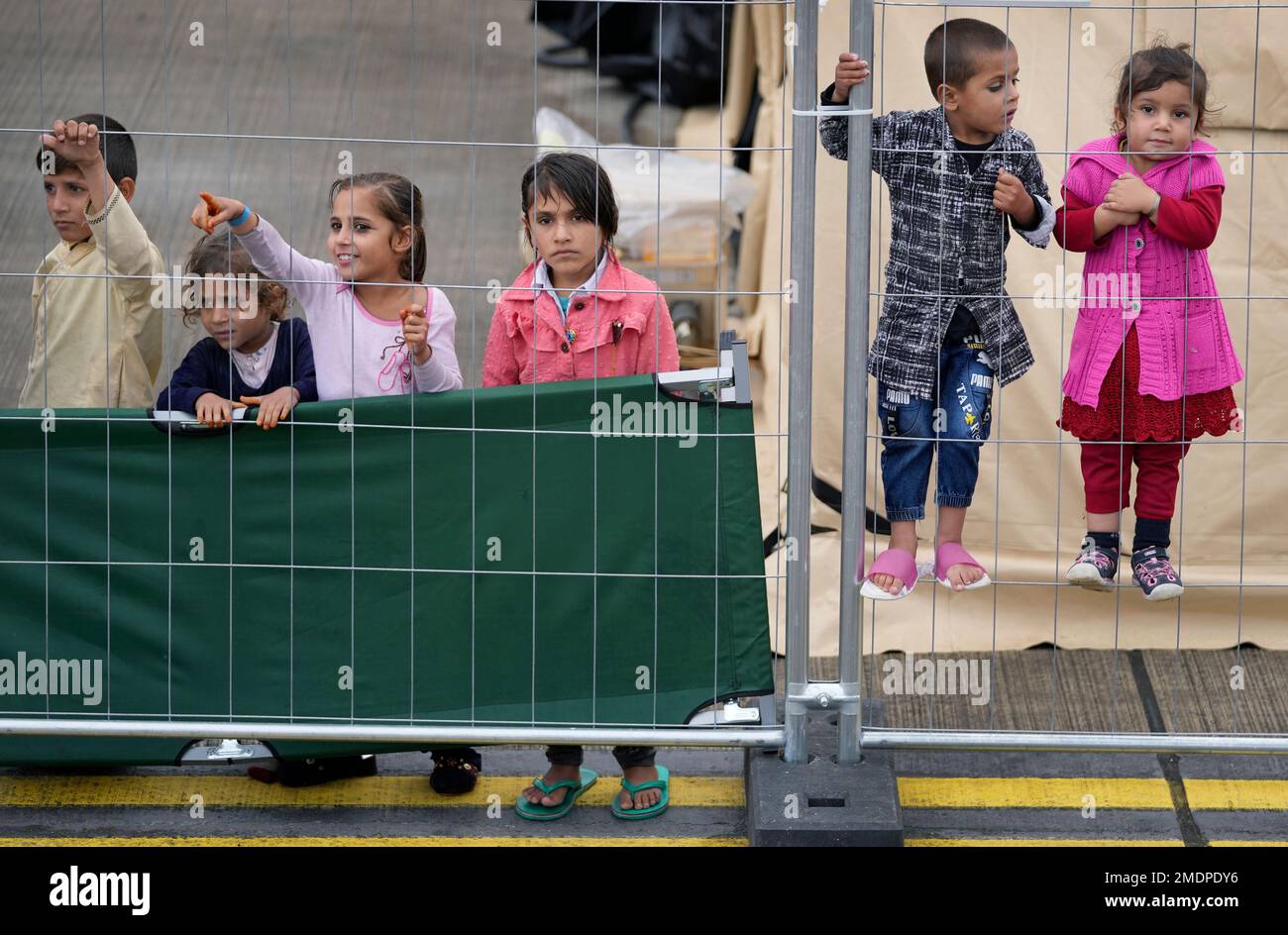 Kids stay behind a fence at the Ramstein U.S. Air Base in Ramstein, Germany,  Monday, Aug. 30, 2021. The largest American military community overseas houses  thousands Afghan evacuees in a tent city
