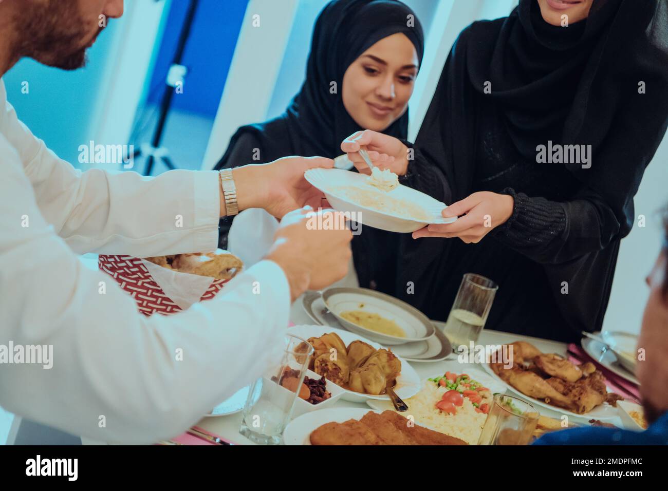 Muslim family having Iftar dinner drinking water to break feast. Eating