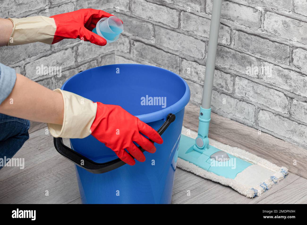 man adding detergent to a bucket of water. detergent for cleaning. wet