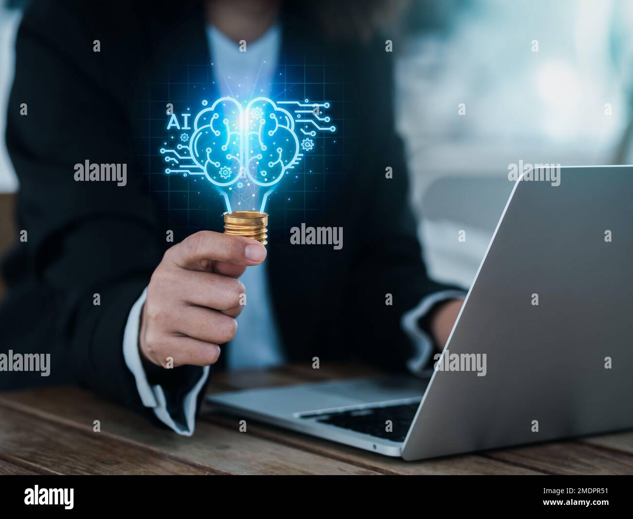 Artificial intelligence technology concept. Glow digital light bulb graphics with AI brain system inside, hold by business person. Creative innovation Stock Photo