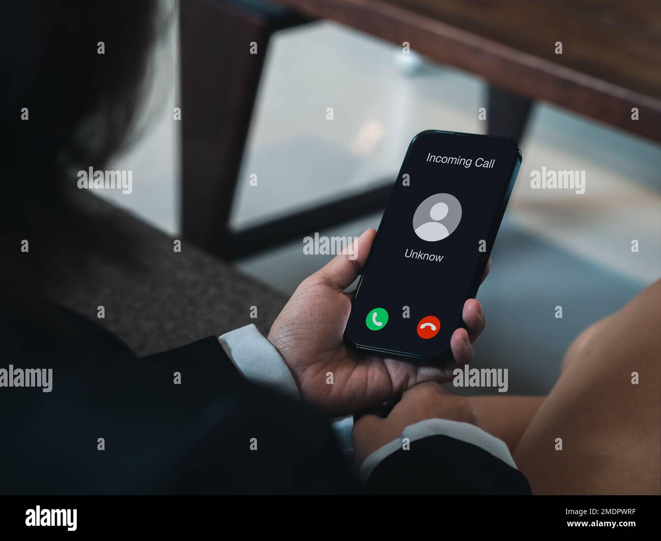 Incoming call with unknown caller, malicious phone calls concept. Unknown number displayed showing on smart mobile phone in business person hand. Spam Stock Photo