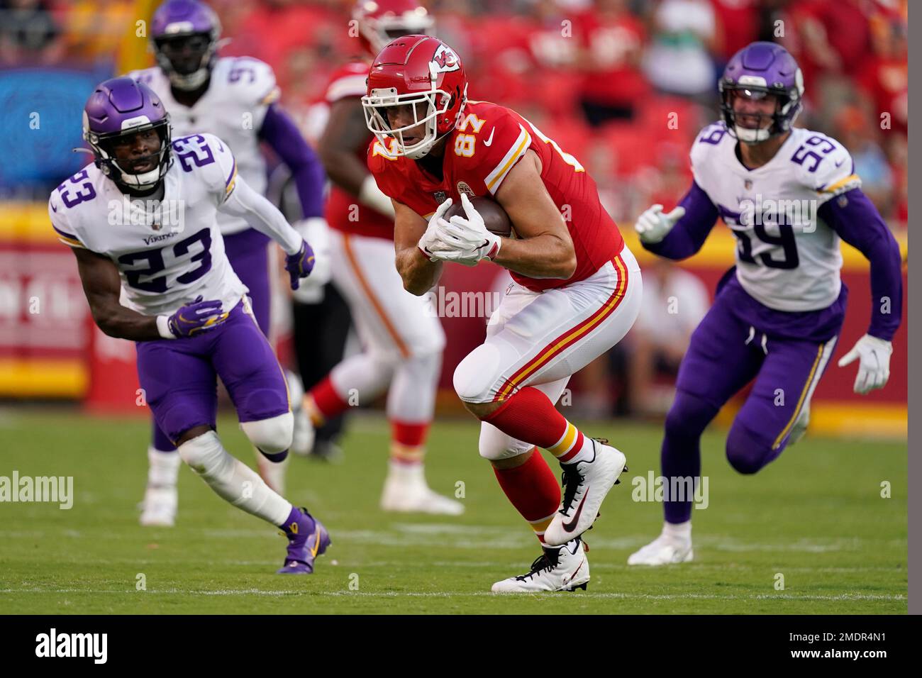 Kansas City Chiefs tight end Travis Kelce (87) catches a pass as Minnesota  Vikings safety Xavier Woods (23) and linebacker Nick Vigil (59) defend  during the first half of an NFL football