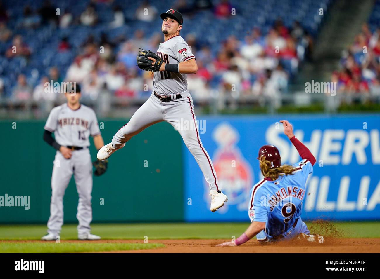 Arizona Diamondbacks second baseman Josh Rojas, center, throws to first  base after forcing out Philadelphia Phillies' Travis Jankowski at second on  a fielder's choice hit into by Odubel Herrera during the seventh