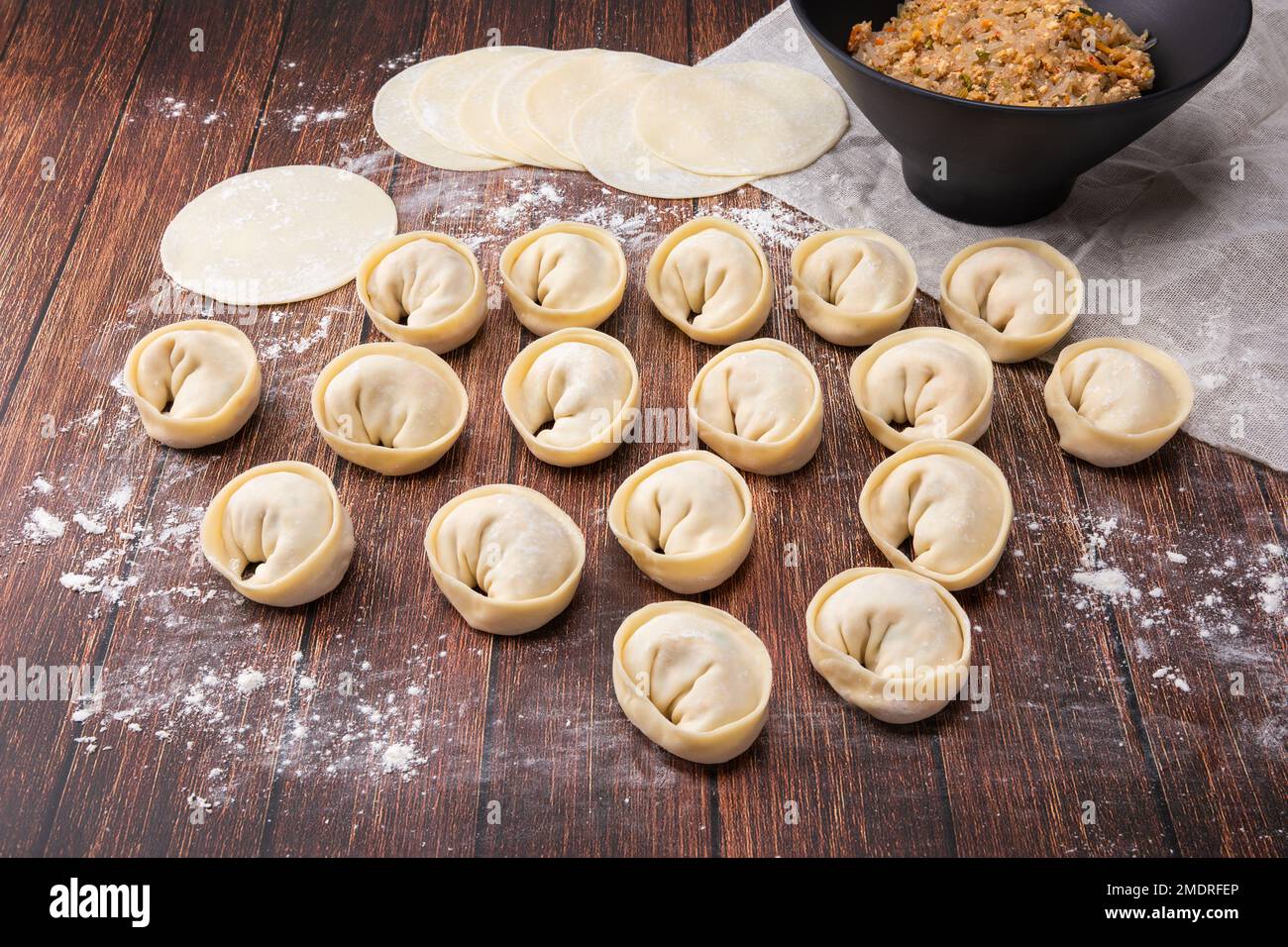 Homemade kimchi dumplings made with wheat flour and shaped into round shapes. Wood deck background, closeup viewed from above. Stock Photo