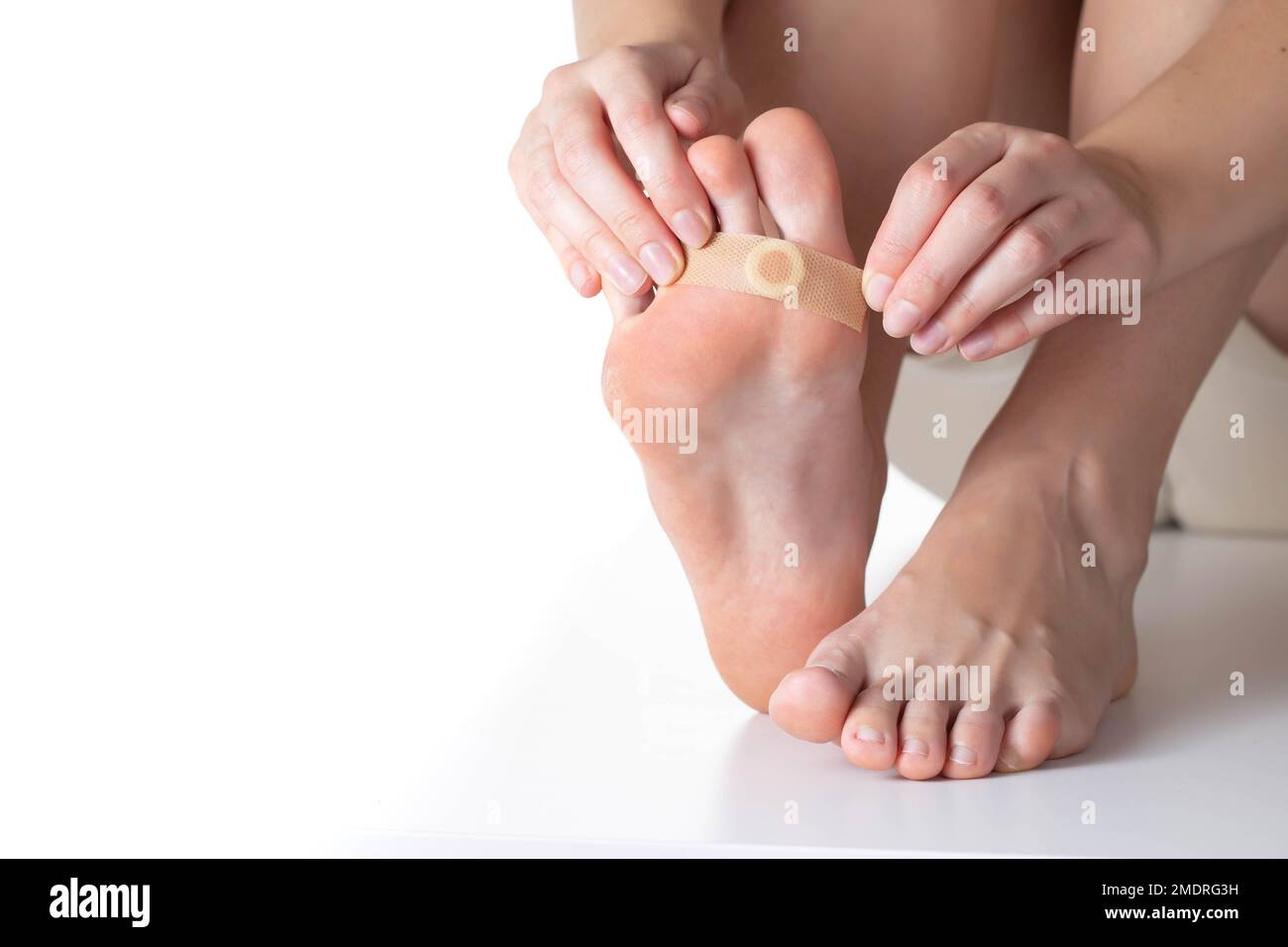 Woman sticks a medical plaster to the plantar wart of the leg to remove